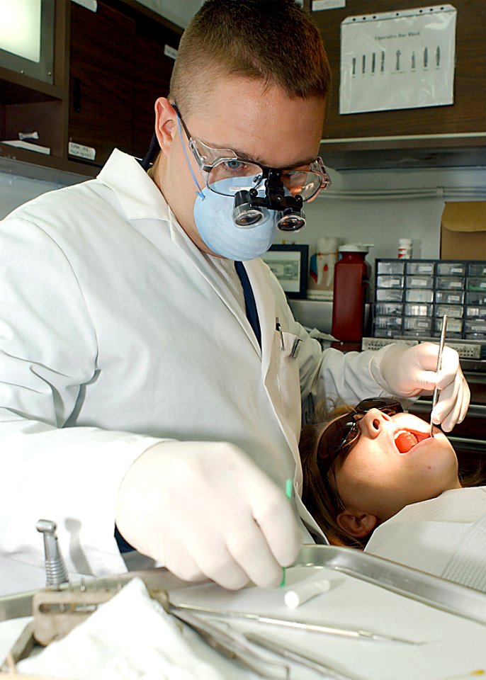 US Navy 020729-N-1280S-001 A Dental Officer works on a Patient in the Ship's Dental Facility