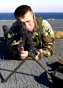 US Navy 030114-N-1512S-005 LCpl Jarret Vaden assigned to the Second Marine Expeditionary Brigade trains on his M-60 machine gun on the ship's flight deck