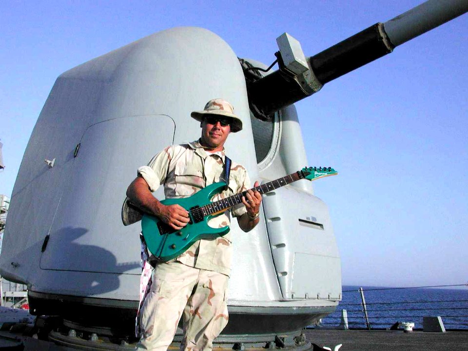 US Navy 020812-N-0625X-001 Chief plays the guitar after an underway replenishment