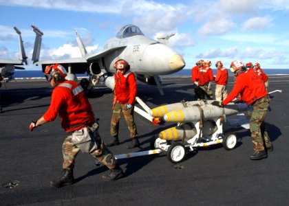 US Navy 030116-N-6895M-509 Aviation Ordnancemen assigned to the Hunters load bombs under the wing of a F-A-18