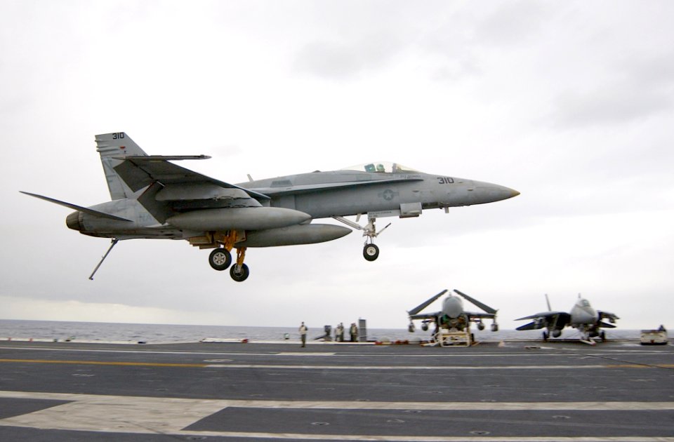 US Navy 030124-N-1810F-010 Hornet with its tailhook down, attempts a controlled landing on the ship's flight deck