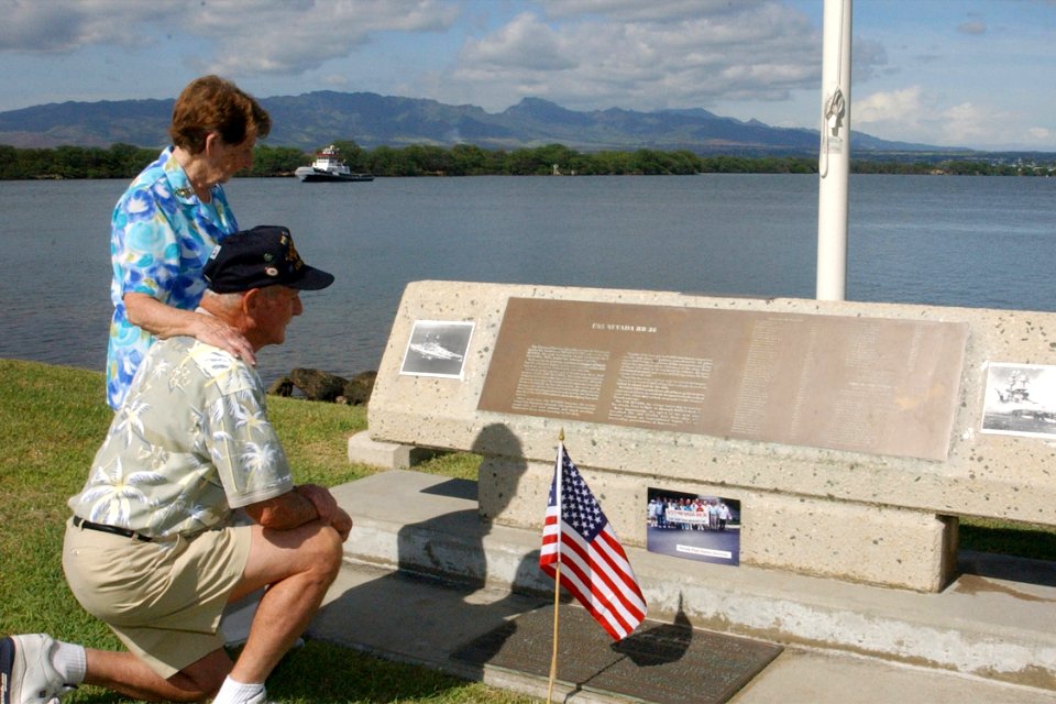 US Navy 021206-N-5812W-001 USS Nevada survivor Woodrow Derby and his wife look silently at photographs and flags they have placed on the USS Nevada Memorial