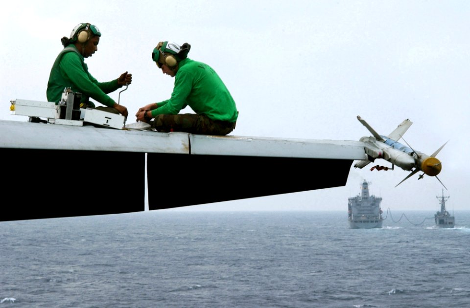 US Navy 021127-N-1810F-009 Sailors work on an aircraft wing aboard the carrier's flight deck