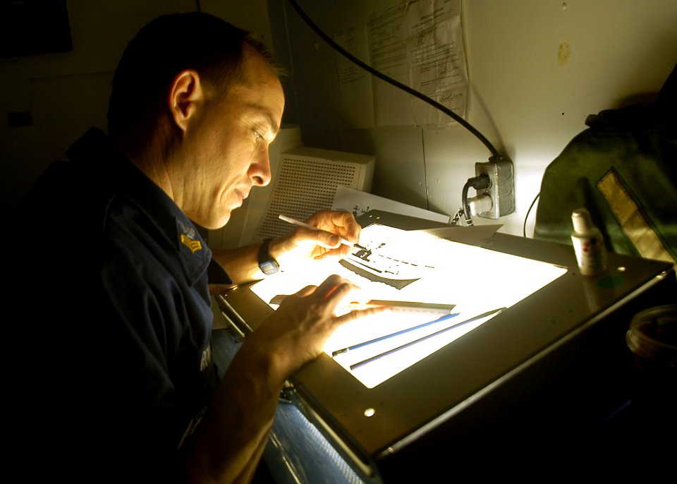 US Navy 030209-N-2972R-079 Illustrator Draftsman designs a training slide with the assistance of a light table