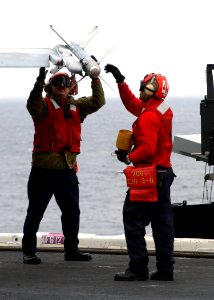 US Navy 021213-N-6895M-505 Aviation Ordnancemen secure ordnance to the wing of an F-A-18 Hornet from Carrier Air Wing Eight (CVW-8) on the ship's flight deck