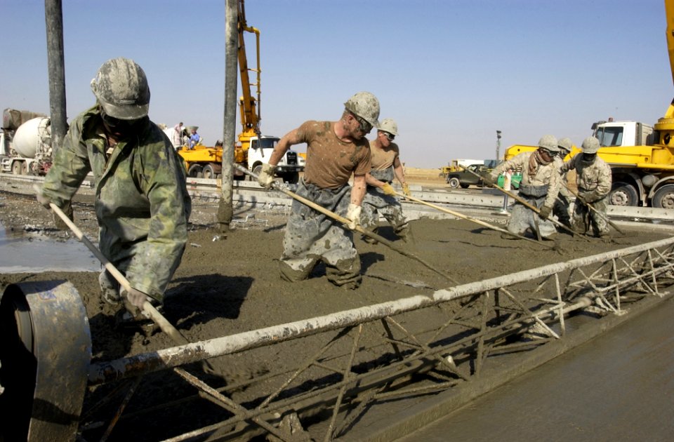 US Navy 030104-N-5319A-002 Seabees attached to Naval Mobile Construction Battalion Seventy-Four (NMCB-74) level out concrete for a C-130 aircraft staging area