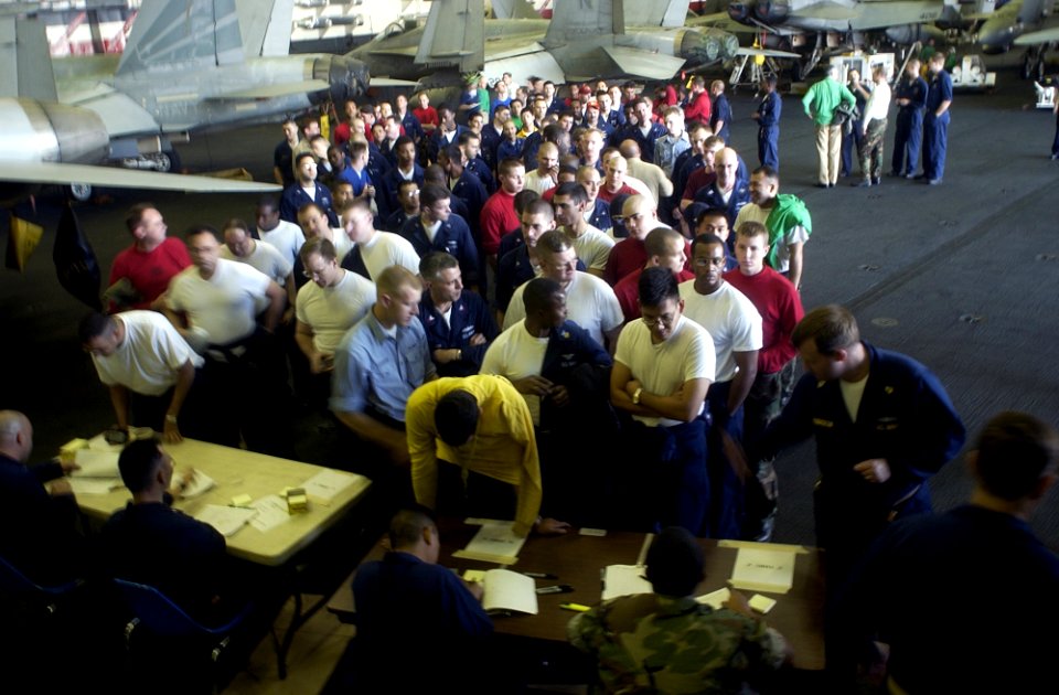 US Navy 030106-N-4142G-011 Crew members line up in the ship's hangar bay to receive the first shot of Bacillusanthracis to build their immune system to Anthrax