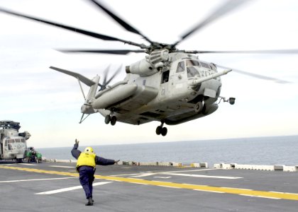 US Navy 030113-N-2972R-040 Aviation Boatswain's Mate 3rd Class Kelvin Banchon directs a CH-53 Sea Stallion helicopter as it departs the ship's flight deck during the onload of the Second Marine Expedit