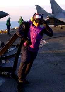US Navy 030114-N-2972R-099 Airman Recruit Prucencio Semana stows a JP-5 jet fuel hose