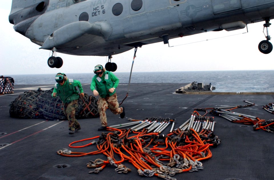 US Navy 021127-N-1810F-002 Sailors from the aircraft carrier's Supply Department retreat from below a CH-46 Sea Knight helicopter