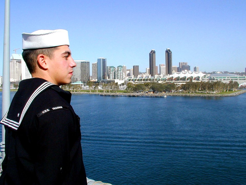 US Navy 030106-N-5666L-001 A crewmember looks on as the ship leaves her homeport of San Diego, Calif