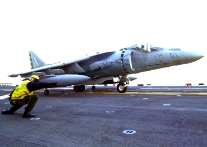 US Navy 030114-N-2972R-036 Aviation Boatswain's Mate 2nd Class Osulado DeLaCruz directs a AV-8B Harrier assigned to Attack Squadron Two Two Three (VMA-223) on the ship's flight deck