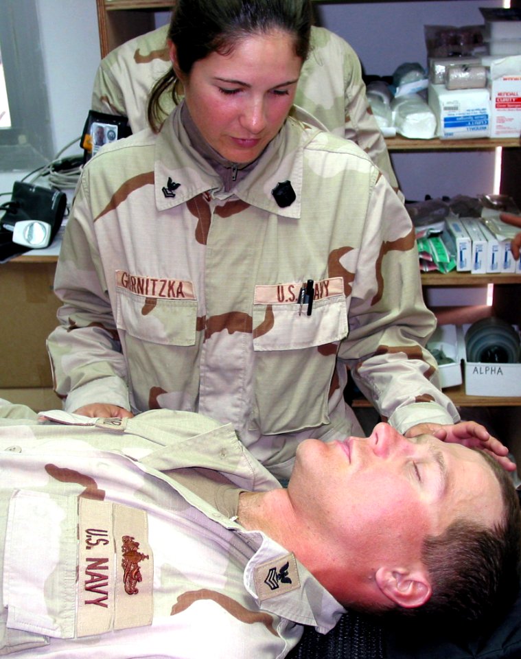 US Navy 030204-N-1050K-010 Hospital Corpsman 2nd Class assesses simulated injuries of a shipmate