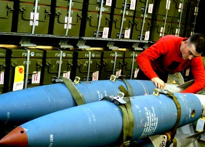 US Navy 030207-N-4048T-060 Aviation Ordnanceman secures bombs to a bomb rack in preparation for heavy seas