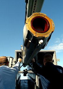 US Navy 030205-N-4048T-069 Fire Controlmen hold the wing clips closed on a NATO RIM-7 Sea Sparrow missile while uploading it into a launcher cell
