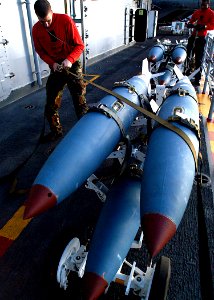 US Navy 030124-N-4048T-105 Aviation Ordnanceman 3rd Class Henry Basiliere secures missiles aboard the amphibious assault ship photo