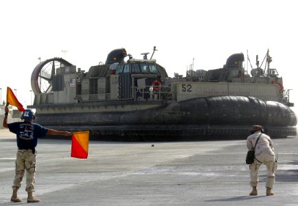 US Navy 030226-N-1050K-040 Keeping the ramp safe and clear, a Beach Master Unit One (BMU-1) ramp marshal directs the craft master of Landing Craft Air Cushion (LCAC) 52