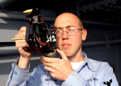 US Navy 030212-N-5786V-501 Quartermaster 3rd Class Justin Bradshaw from Lapeer, Mich., uses a sextant to determine the ship's position while on watch on the ship's signal bridge