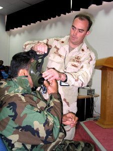US Navy 030305-N-1050K-005 instructs an United Arab Emirates (UAE) Airman in the proper donning and wearing of a protective mask