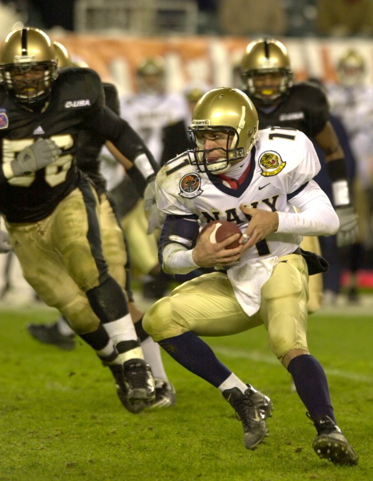 US Navy 031206-N-9693M-505 Navy quarterback Craig Candeto looks for an opening as he rushes downfield during the 104th Army Navy Game