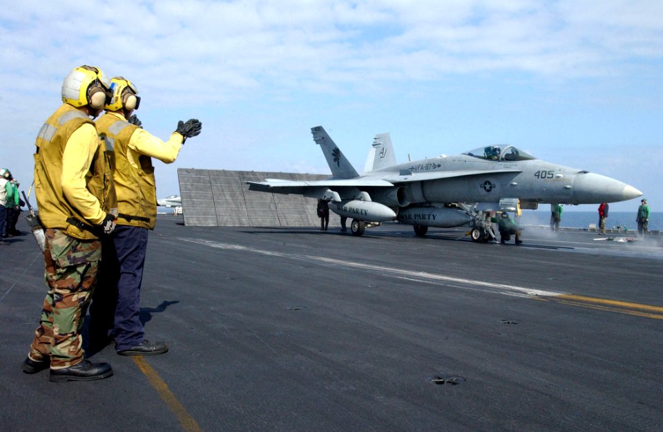 US Navy 030314-N-6895M-515 Aviation Boatswain's Mates direct an F-A-18C Hornet into launching position on the flight deck