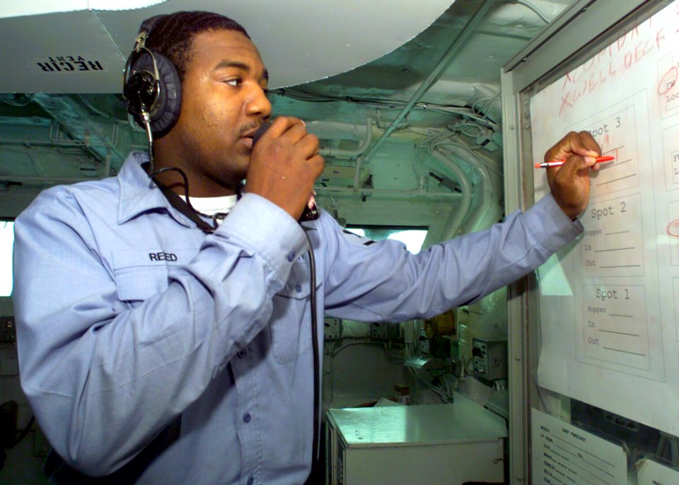 US Navy 030218-N-2972R-078 Aerographer's Mate 3rd Class John Reed updates a status board to track the ship's Landing Craft Air Cushions (LCACs)