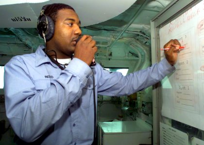 US Navy 030218-N-2972R-078 Aerographer's Mate 3rd Class John Reed updates a status board to track the ship's Landing Craft Air Cushions (LCACs)
