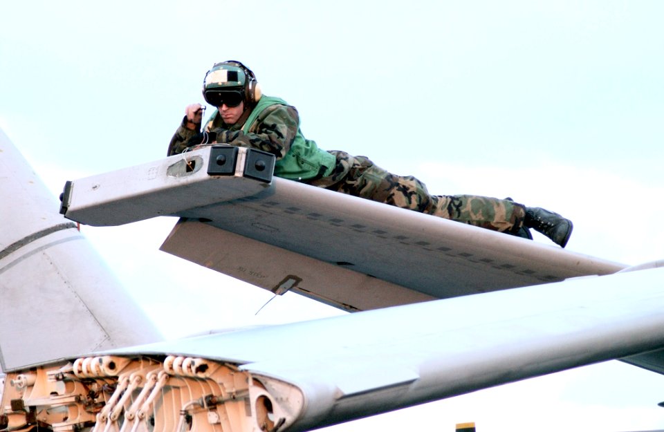 US Navy 030221-N-1328C-505 Aviation Electrician Mate 3rd Class Rockford Vansach repairs electrical systems in the wing of an S-3B