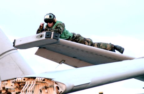 US Navy 030221-N-1328C-505 Aviation Electrician Mate 3rd Class Rockford Vansach repairs electrical systems in the wing of an S-3B