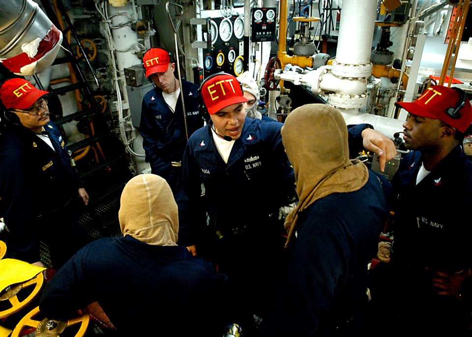 US Navy 030314-N-4048T-044 The Engineering Training Team (ETT) instructor provides feedback to watch standers in one of the main machinery spaces aboard the amphibious assault ship USS Kearsarge (LHD 3)