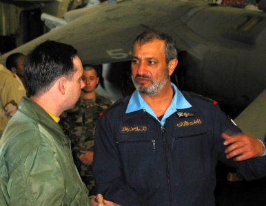 US Navy 030227-N-1050K-043 Maj. Gen. Ahmad Y. Al Mulla, Kuwaiti Chief of Naval Forces, discusses hangar bay operations with Aviation Boatswain's Mate 2nd Class James Penkert during a recent visit photo