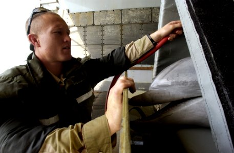 US Navy 030317-N-5319A-010 Signalman 2nd Class Harlold Bickford a mammal handler assigned to Commander Task Unit 55.4.3 (CTU-55.4.3) sprays water on a Bottle Nose Dolphin before transporting