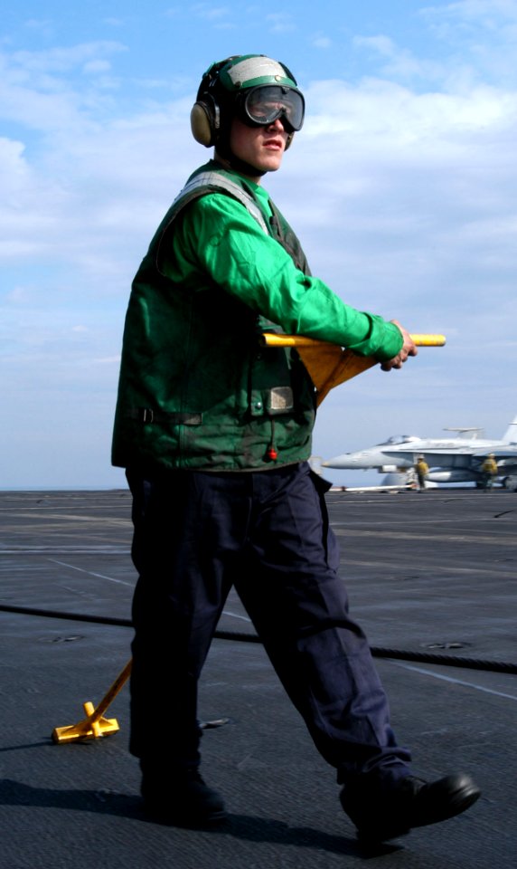 US Navy 030310-N-5786V-505 Airman James Lackofsky prepares to push the cable back from the foul line on the flight deck aboard USS Theodore Roosevelt (