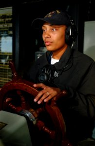 US Navy 030303-N-5319A-009 Seaman Shawnrayell Foster drives the 609-foot amphibious dock landing ship USS Comstock (LSD 45) during her 4-hour deck watch on the bridge