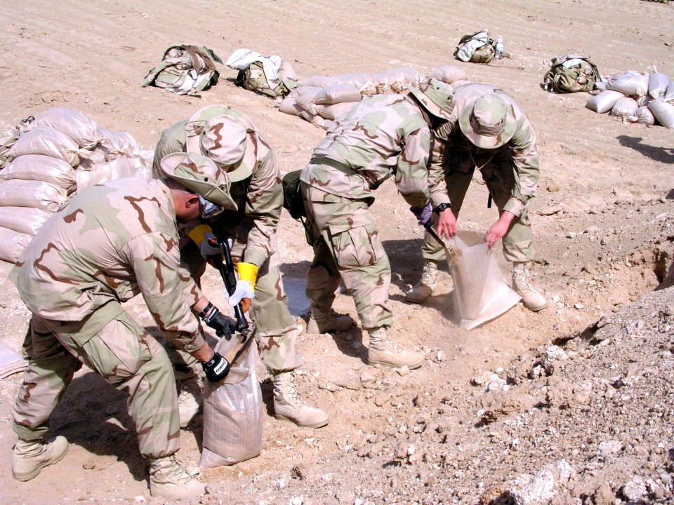 US Navy 030312-N-0728B-006 Sailors and Marines assigned to Fleet Hospital Three fill sand bags to fortify their new compound shortly after arriving in the Central Command Area of Operations