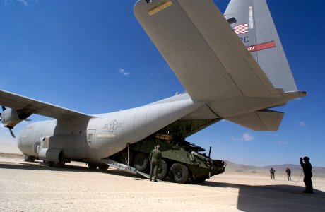 US Navy 030324-A-0000O-006 A Stryker Mortar Carrier exits the tail of an Air Force C130 Hercules aircraft after landing at the Army National Training Center's 'Bicycle Lake' Army airfield