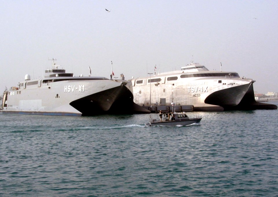 US Navy 030225-N-1050K-001 Sealift vehicles belonging to the U.S. Navy and U.S. Army sit together pier side under the watchful eye of both the U.S. and Kuwaiti harbor patrol