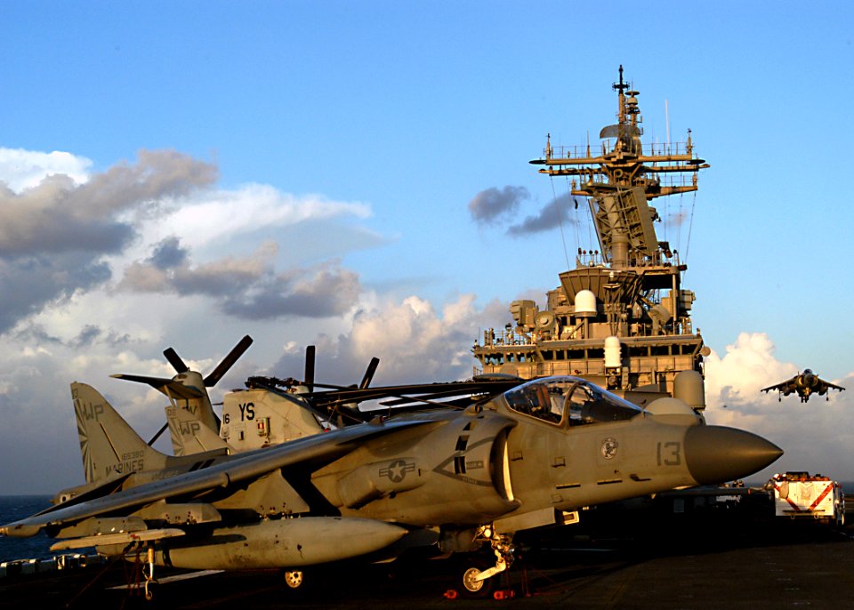 US Navy 030203-N-4048T-009 An AV-8B Harrier rests aboard Kearsarge as another (right) descends to land on the flight deck aboard the Wasp-class amphibious assault ship