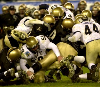 US Navy 031206-N-9693M-517 Army and Navy football players vie for control of the ball during the 104th Army Navy Game photo