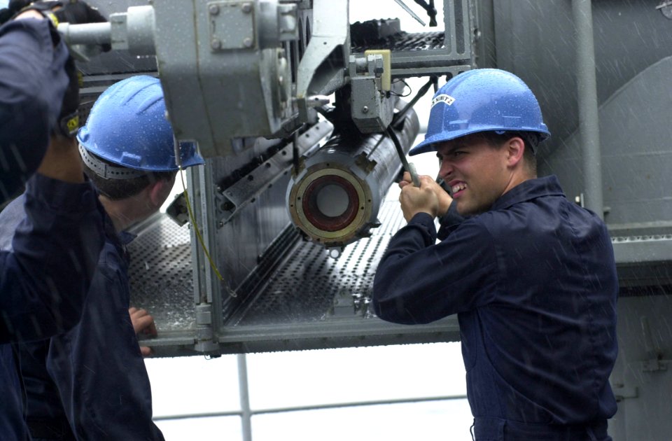 US Navy 030317-N-2143T-002 Fire Controlman 2nd Class Damien Bernicky loads a live NATO RIM-7 surface-to-air missile into one of the ship's missile launchers