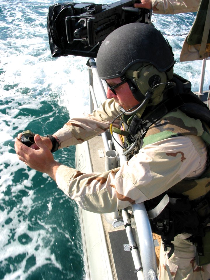 US Navy 030315-N-1050K-035 Machinist's Mate 3rd Class Donald Weber, a recalled reservist from Dubuque, Iowa, prepares to pull the pin on a concussion grenade he will drop in the waters of the North Arabian Gulf