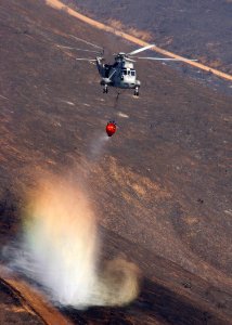 US Navy 031029-N-5067K-087 A UH-3H Sea King helicopter drops a load of water