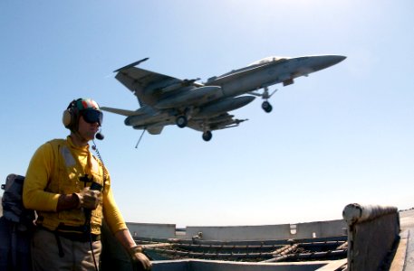 US Navy 030328-N-1810F-001 U.S. Navy Lt. Mark Kekeisen from Lakehurst, N.J., stands duty as safety observer along the flight deck foul-line as an F-A-18C Hornet lands aboard the aircraft carrier USS Kitty Hawk (CV 63)