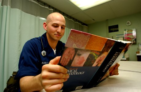 US Navy 030319-N-6077T-009 ospital Corpsman Matthew Moritz, of Bronx, N.Y., examines a dermatology reference manual