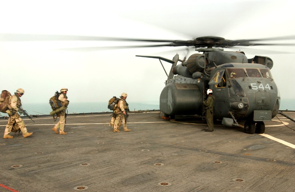 US Navy 030320-N-5319A-012 Dive Platoon service members assigned to Commander Task Unit (CTU-55.4.3) transit the flight deck to board a MH-53 Sea Dragon