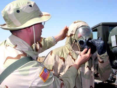 US Navy 030226-N-1050K-053 United States Army Sgt. Nichols lends a hand to ensure a Sailor has a good seal on his MCU2P protective mask as part of continued joint training exercises taking place in Kuwait