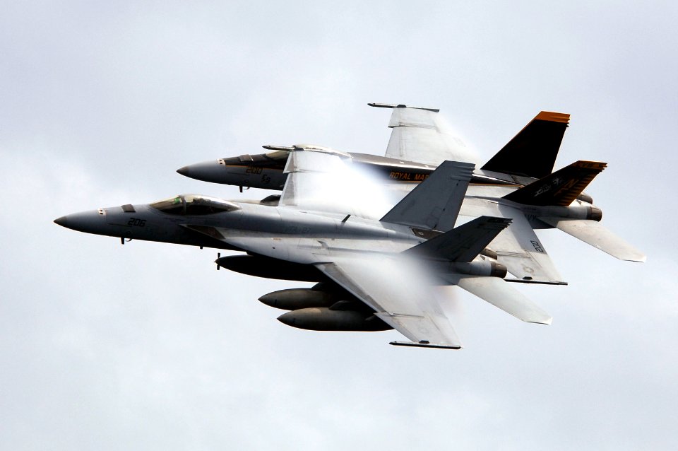 US Navy 070923-N-3136P-109 Water vapor flows over the wings of two F-A-18E Super Hornets