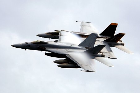 US Navy 070923-N-3136P-109 Water vapor flows over the wings of two F-A-18E Super Hornets
