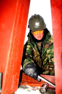 US Navy 030302-A-8380W-001 Sailor bolts down a steel beam