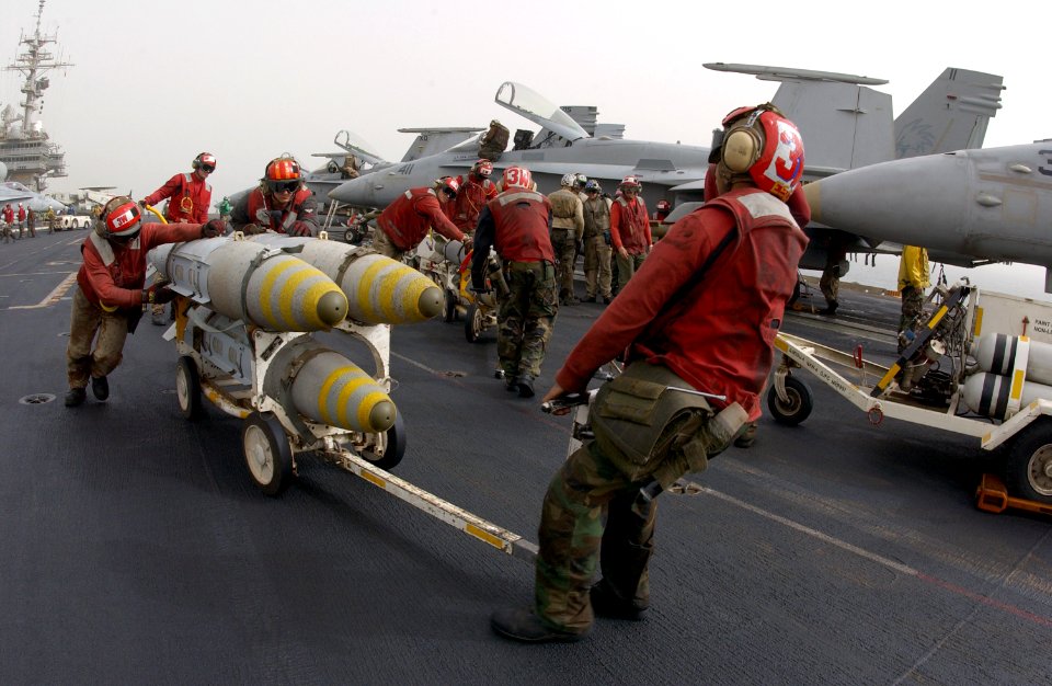 US Navy 030327-N-1810F-023 Aviation ordnancemen transfer GBU-31 joint defense attack munitions (JDAM) to ready Carrier Air Wing Five (CVW-5)